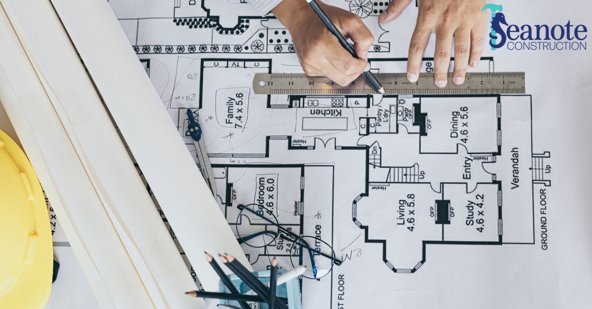 Person drawing on architectural plans