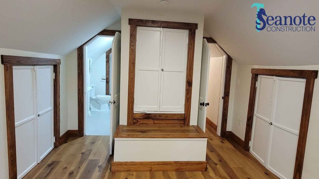 Attic bathroom and storage with wooden trim.