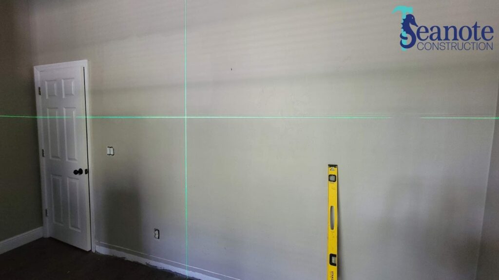 Wall under construction with laser level and tools.