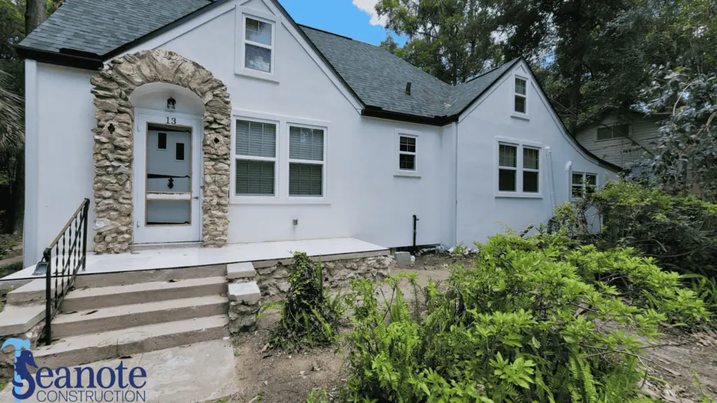 Front view of renovated white house with stone accents.