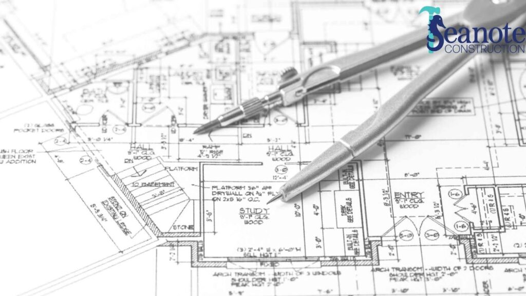 Architectural plans with drafting tools on top