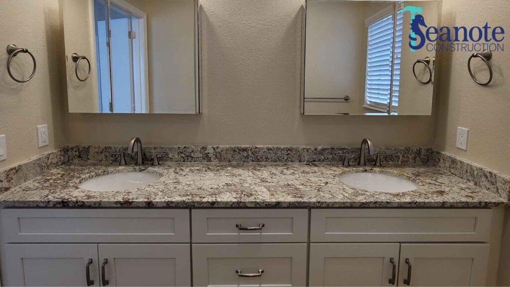 Modern bathroom with marble countertop and dual sinks.