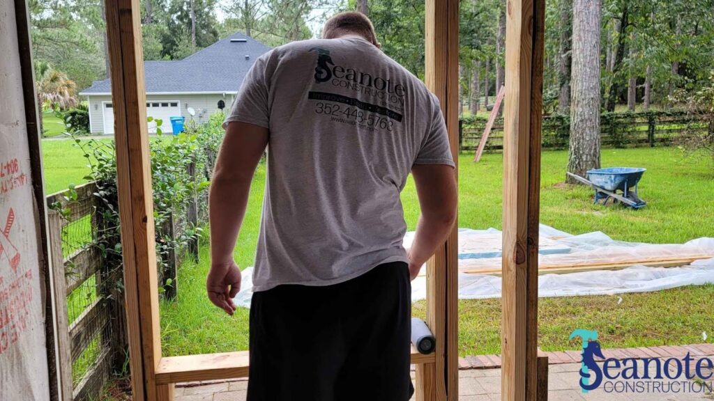 Construction worker building wooden structure outdoors.