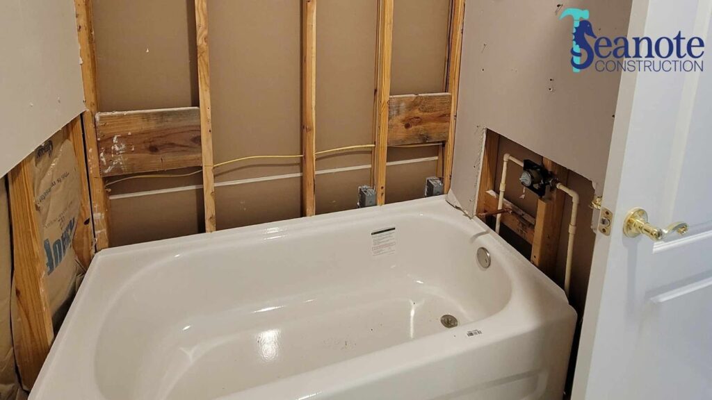 Bathroom under renovation with exposed wooden framing.