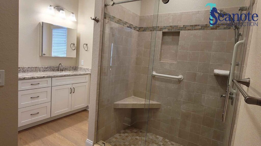 Modern bathroom with glass door and granite countertop.