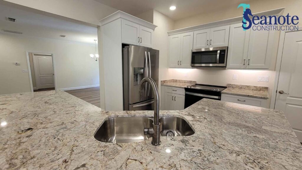 Modern kitchen with granite countertop and stainless appliances.