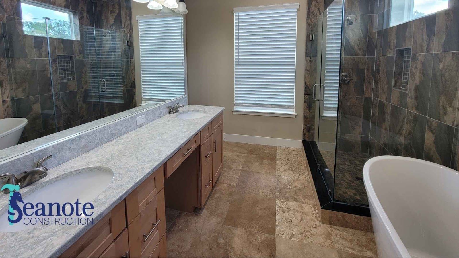 Full bathroom with marble counter and glass shower