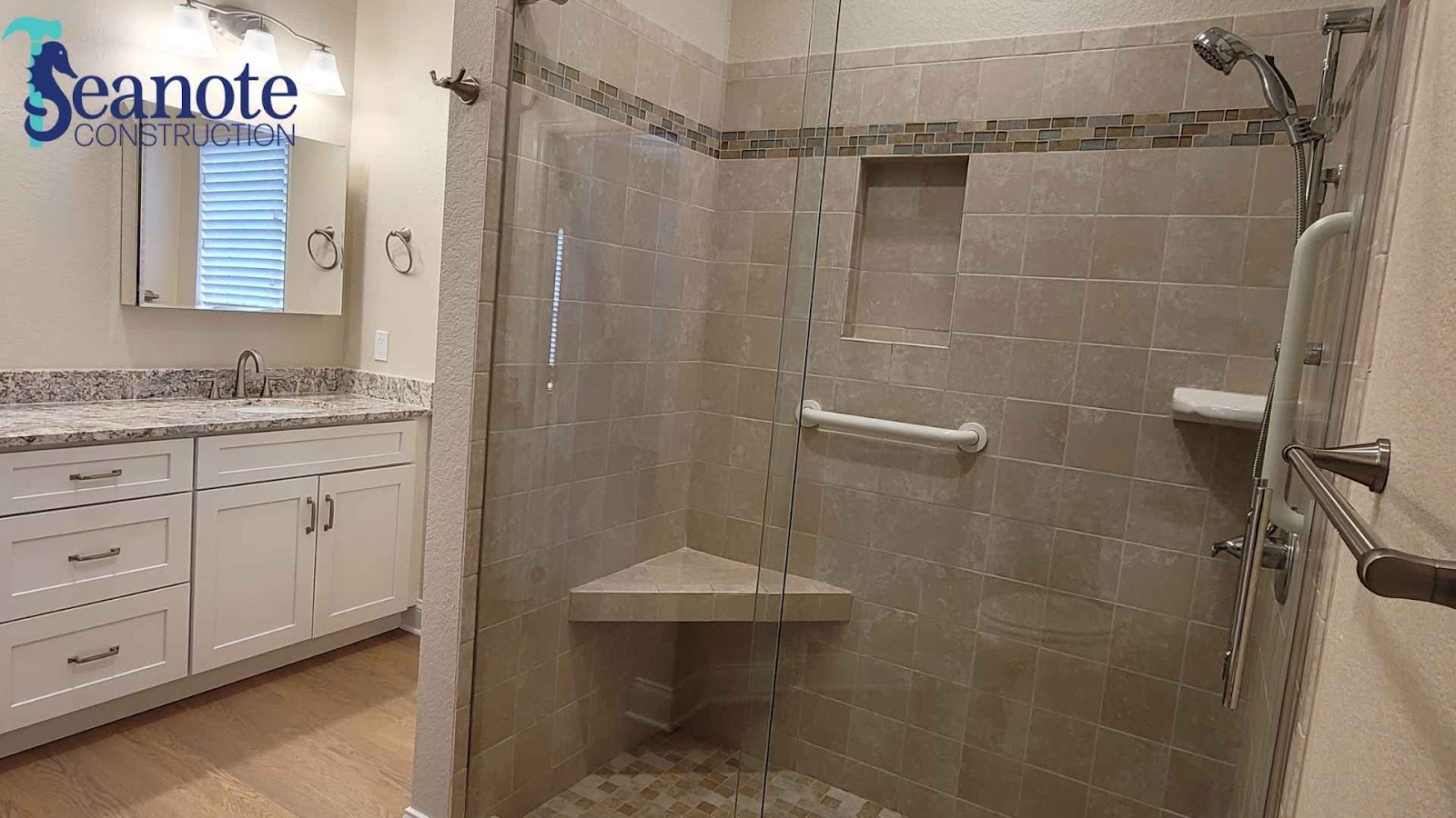 Three-quarter bathroom with tiled shower and vanity.