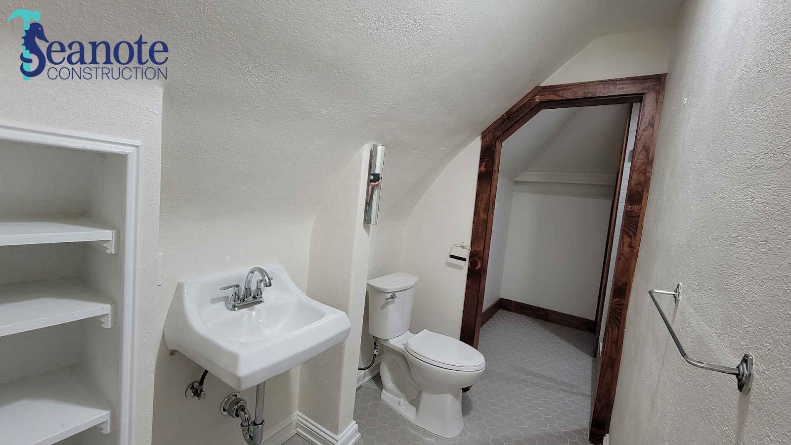 Half bathroom with sink, toilet, and shelves
