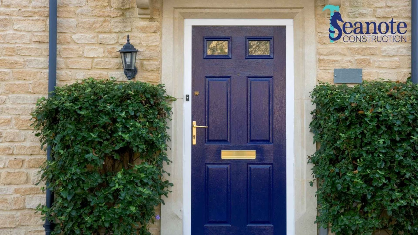 Blue exterior door with brick wall and greenery
