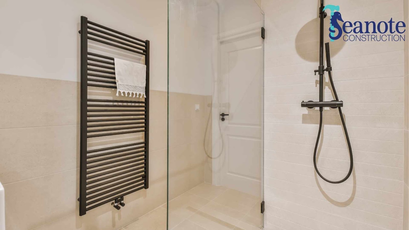Modern bathroom with glass shower and towel rack.