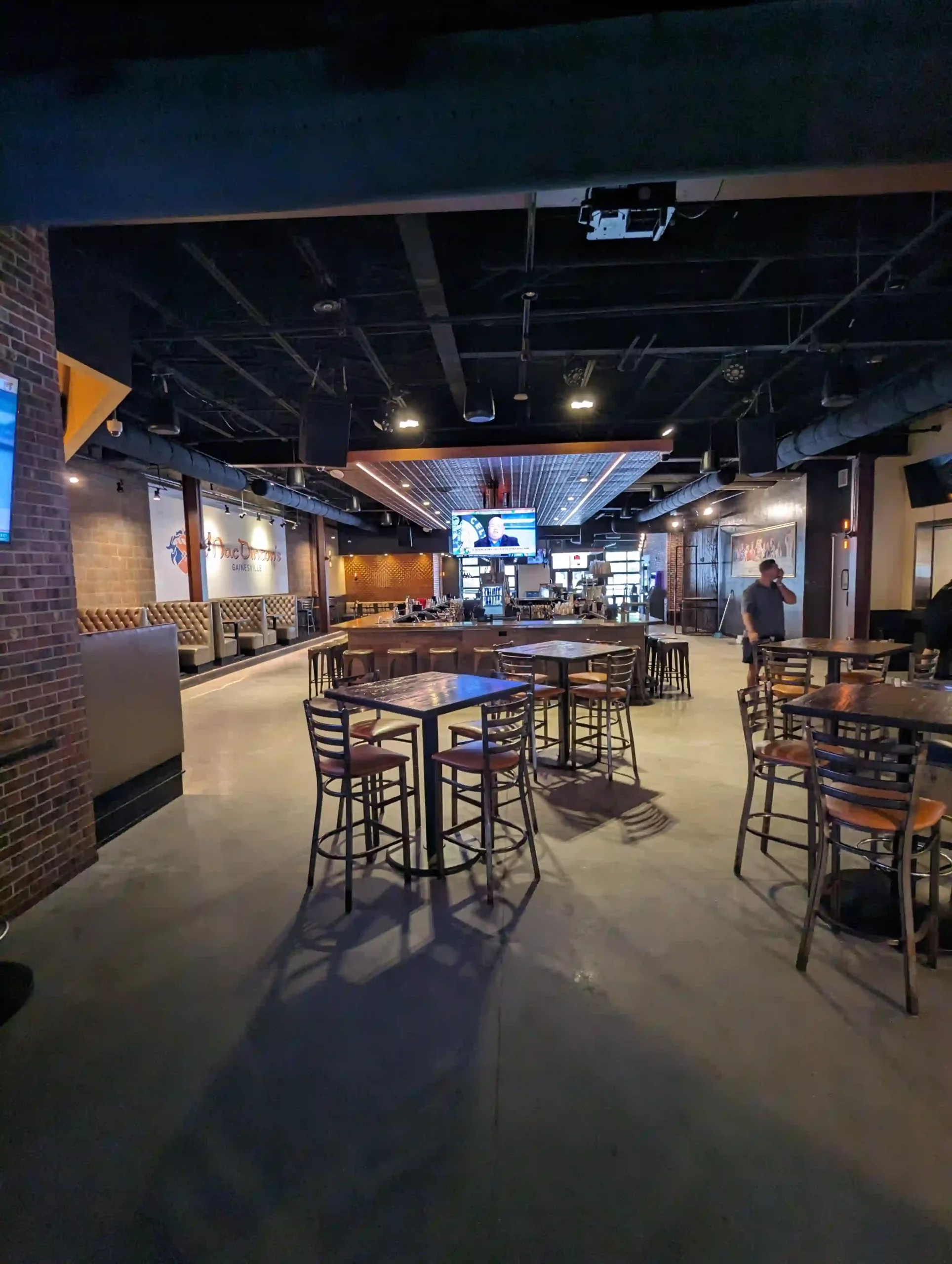 Empty bar interior with wood tables and seating.