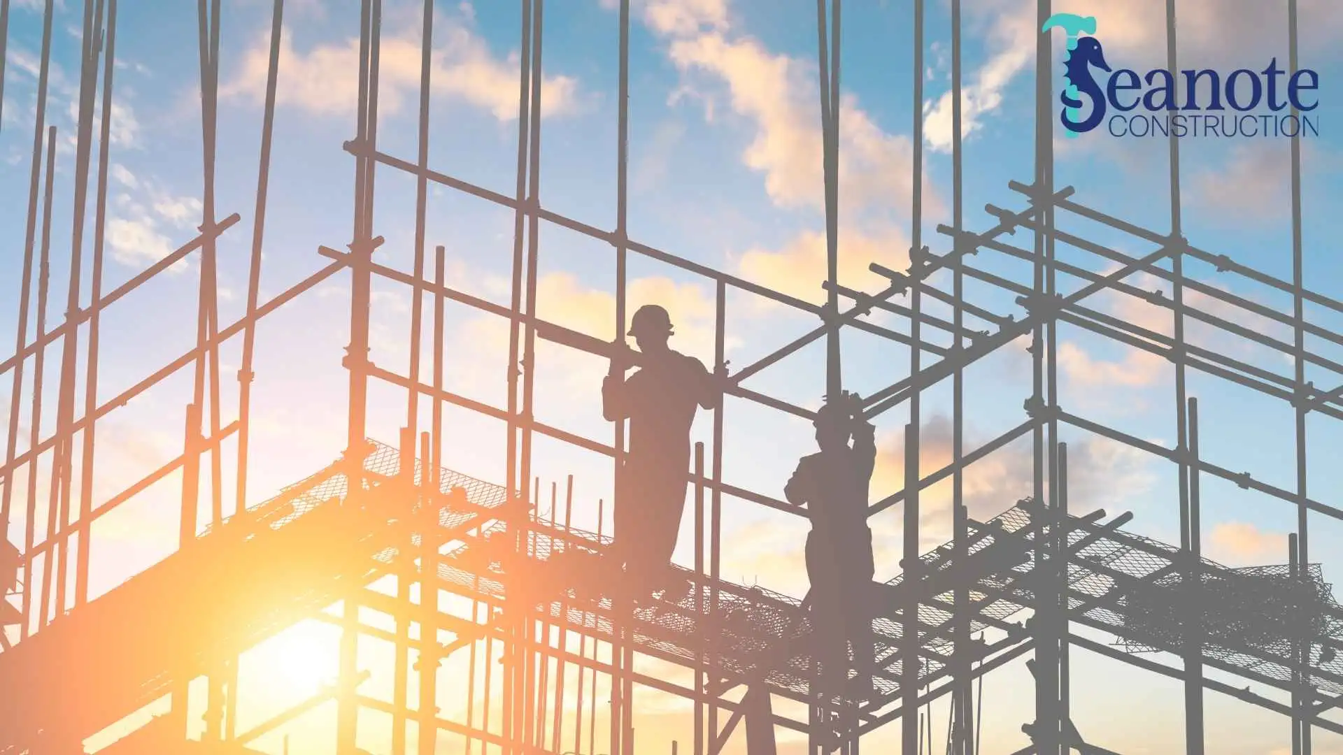 Construction workers on scaffolding at sunset