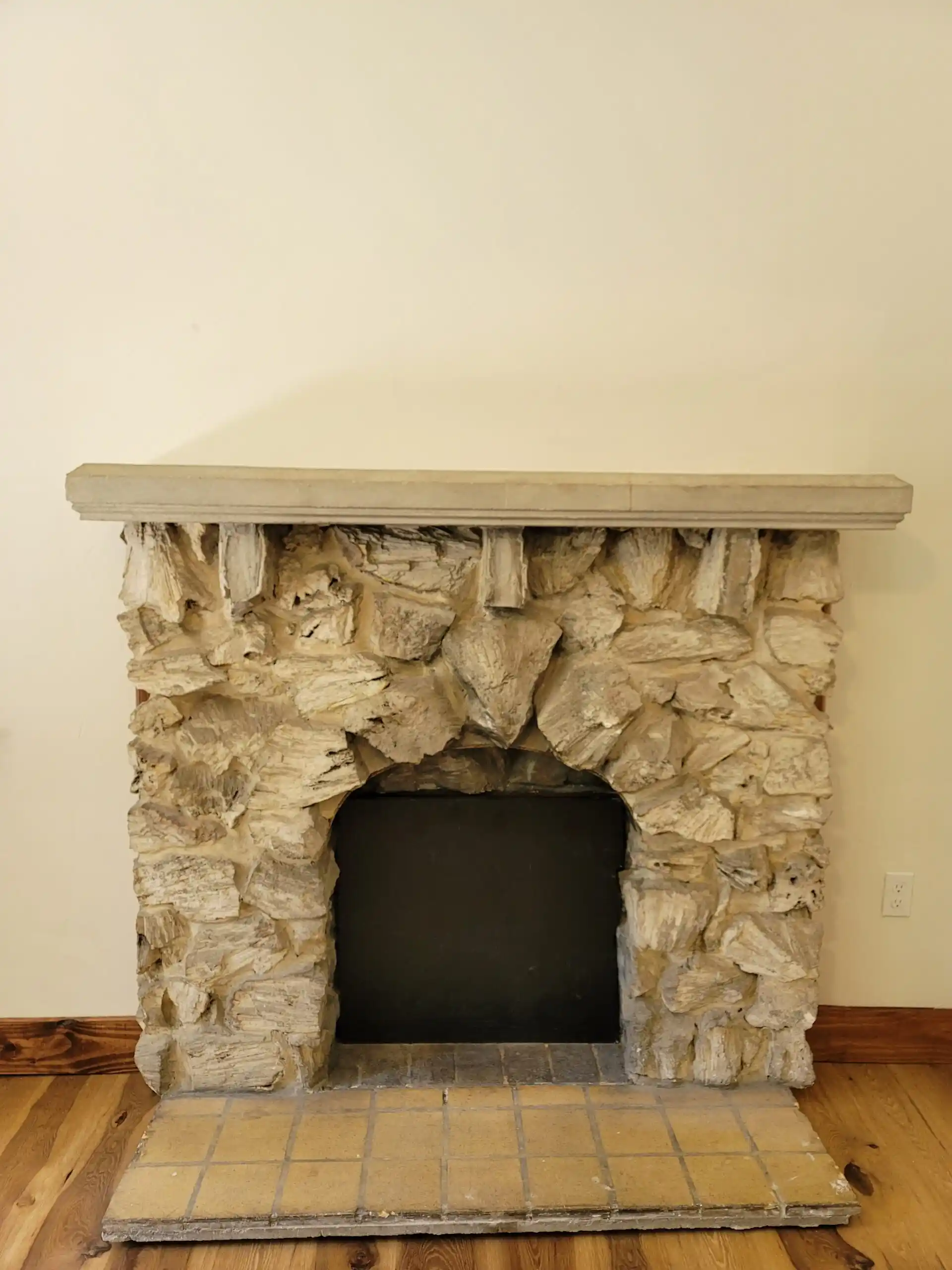 Rustic stone fireplace with wooden mantel