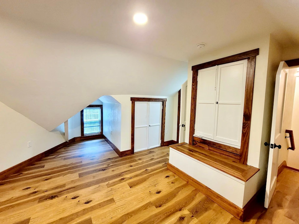 Cozy attic room with wood floors and storage