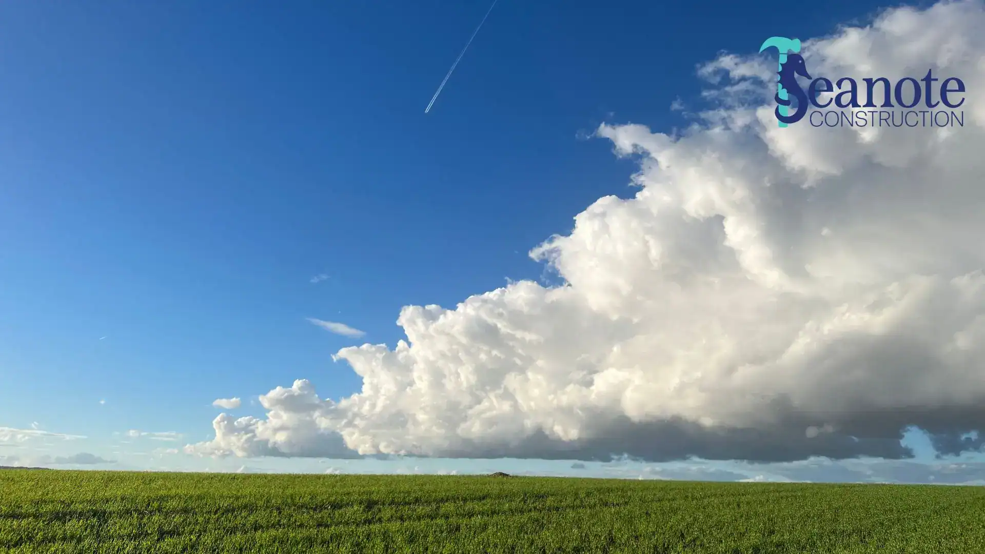 Large cumulus clouds over green field