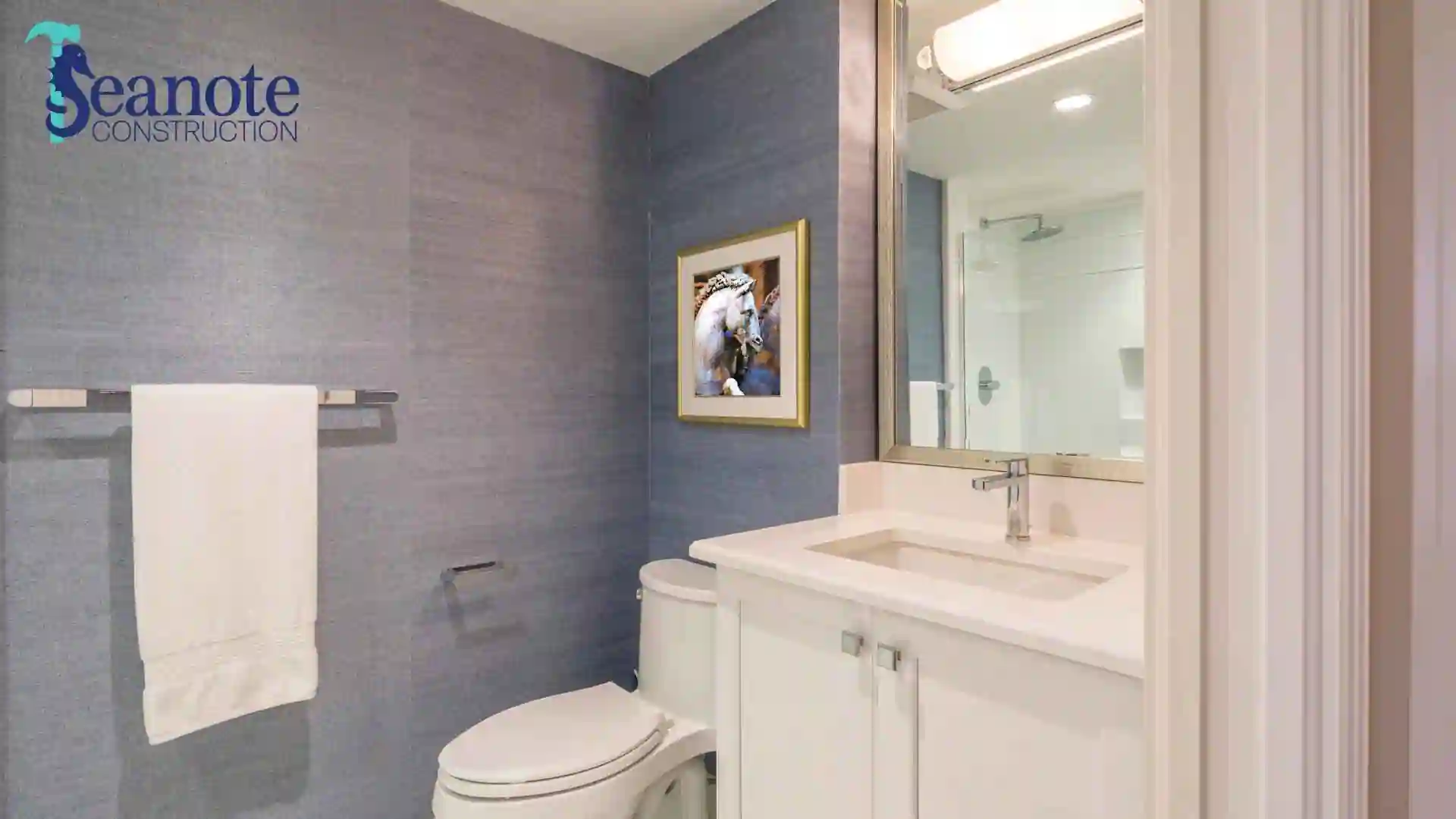 Elegant modern bathroom featuring a walk-in shower, sink, and toilet with a stylish wooden finish, illustrating bathroom remodeling in Ponte Vedra Beach. Branded with the Seanote Construction logo.